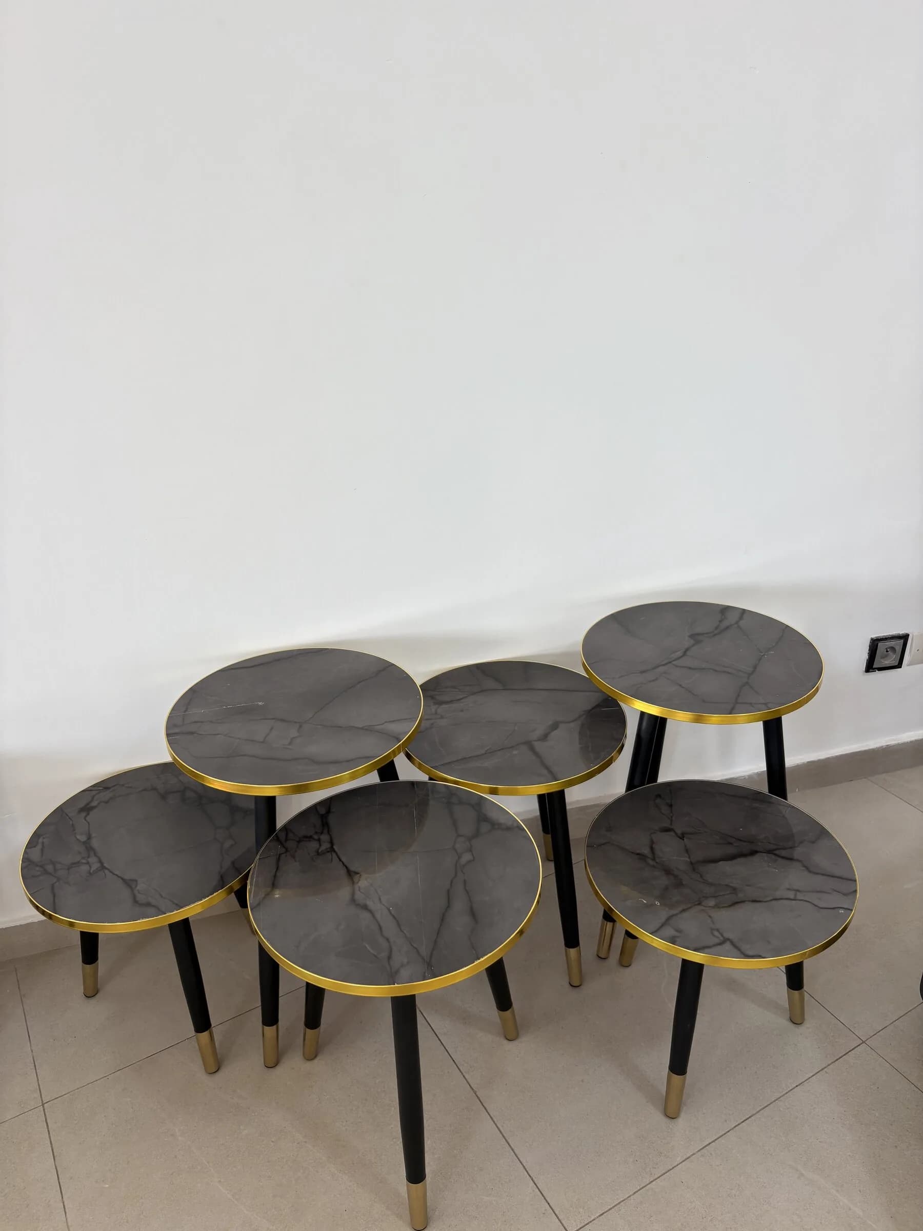 Cinq tables gigognes aux plateaux effet marbre gris cerclés de doré